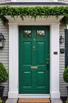 a green front door with white trim and black shutters