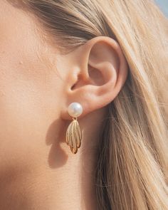 Indulge in luxury with our Chérie Drop Studs. These elegant earrings feature lustrous pearls, hand-selected for their exquisite beauty. The delicate drop design adds a touch of sophistication to any outfit, making these studs the perfect statement piece for any occasion. Material: 14K gold or rhodium plated brass, shell pearls Features: 1.25" drop, 0.3" stud, 0.95" charm, 9mm pearls, Lead & Nickel free, post back Classic Metal Earrings With Pearl Charm, Classic Metal Pearl Earrings With Pearl Charm, Elegant Pearl Chain Earrings In Metal, Elegant Metal Pearl Earrings For Pierced Ears, Elegant Pearl White Metal Pearl Earrings, Elegant Metal Pearl Drop Bridal Earrings, Elegant Metal Bridal Earrings With Pearl Drop, Feminine Pearl Drop Earrings For Evening, Metal Drop Earrings With Pearl Charm