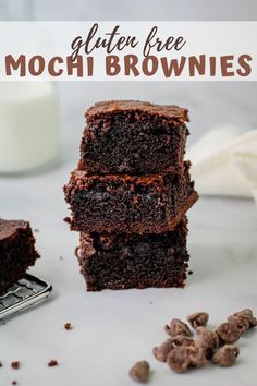 three brownies stacked on top of each other with chocolate chips and milk in the background