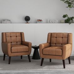 two brown chairs sitting next to each other on top of a carpeted floor in front of a white wall