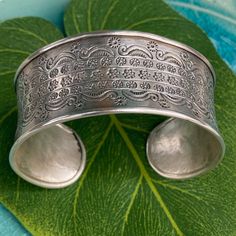 An exquisite work of art this Silver Cuff Bracelet was handmade by the Karen Hill Tribe in Northern Thailand.  The Karen people have spent centuries living and working close to nature and you can see their appreciation here in their hand-hammered work and details.   This bracelet is 98.5% Silver.  The high silver content produces a softer workable metal and will be able to mold to your wrist for the perfect fit.   * Fast U.S Based Shipping * Measures 5.5 " L x 2.5 " W  * 29 Gram Silver  * Ships Bohemian Adjustable Cuff Bracelet With Intricate Design, Artisan Bangle Cuff Bracelet For Festivals, Adjustable Nature-inspired Cuff Bangle Bracelet, Handmade Adjustable Bangle For Ceremonial Occasions, Unique Adjustable Bracelets With Intricate Design, Artisan Adjustable Cuff Bracelet With Intricate Design, Artisan Cuff Bracelet With Intricate Adjustable Design, Adjustable Intricate Cuff Bracelet For Ceremonial Use, Handmade Artisan Cuff Bracelet