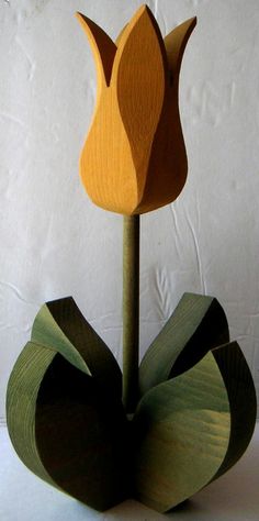 a wooden sculpture with a flower on top of it