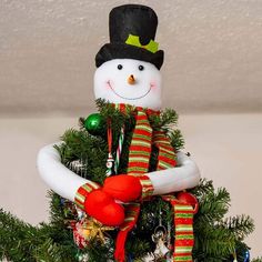 a small christmas tree with a snowman on top