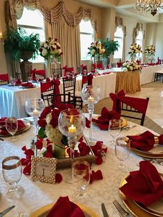 the table is set with red napkins and place settings