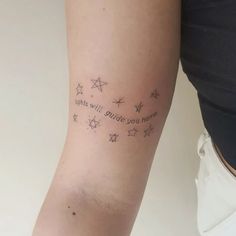 a woman's arm with stars and writing on it