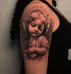 a woman with a tattoo on her arm holding a small child's head and wings