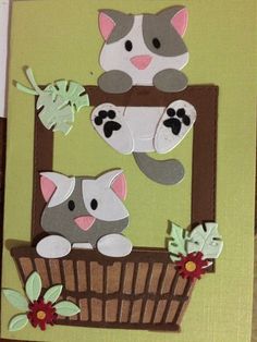 a card with two cats sitting in a basket on top of each other and flowers