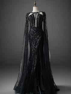 Make a dramatic entrance in this stunning Black Sequin Evening Dress. This exquisite gown features intricate beading and sequin embellishments that create a captivating sparkle. The dress boasts a figure-flattering silhouette with a high neckline and a daring cut-out detail at the front, adding a touch of allure. Dramatic Cape Sleeves: The long, flowing cape sleeves add a regal touch, creating a sense of grandeur and elegance. Intricate Beading and Sequins: The gown is adorned with detailed beading and sequin patterns, making it a true masterpiece of craftsmanship. Figure-Flattering Silhouette: Designed to accentuate your curves, this dress features a fitted bodice that flows into a graceful skirt. Perfect for evening events, galas, or any special occasion where you want to make a statemen Dramatic Black Dress Gowns, Long Black Ball Gown, Black And Purple Evening Gown, Black And Silver Fantasy Dress, Regal Dress Gowns, Fantasy Gowns Black, Black Fantasy Dress Queens, Night Court Dress, Dark Fantasy Gown