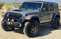 a gray jeep is parked in the desert