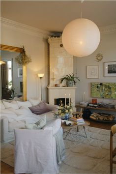 a living room filled with furniture and a fire place in front of a mirror on the wall