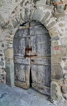 an old stone building with two wooden doors