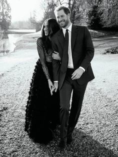 a man in a suit and tie standing next to a woman wearing a long black dress