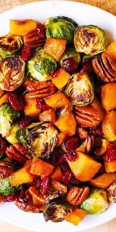 a white plate topped with brussel sprouts and sweet potatoes