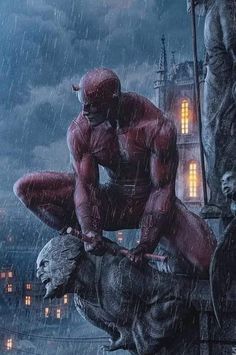 a man sitting on top of a statue in the rain