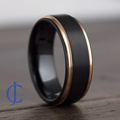 a black and gold wedding ring on a wooden table