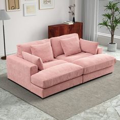 a pink couch sitting on top of a rug in a living room