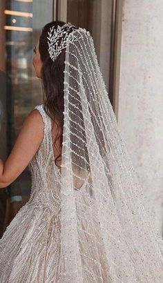 the back of a bride's wedding dress, with her veil draped over her head