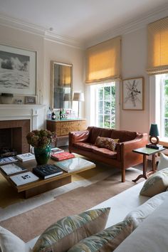 a living room filled with furniture and a fire place in front of a large window