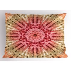 a red and yellow tie dye pillow on a white wall with the image of a flower