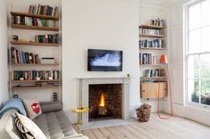 a living room filled with furniture and a fire place in front of a flat screen tv