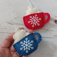 two handmade christmas ornaments with snowflakes hanging from the strings on a white wooden table