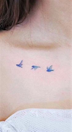 a woman's chest with three birds tattoo on her left side ribcage