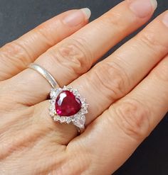 Sterling silver ring with ruby red heart.  * Metal: 925 sterling silver * Stone type: Synthetic  * Stone color: Garnet or Ruby red * Weight: 6.2 grams * Center stone size: 10mm * Stamp: 925 * Ring band width at back of ring: 3mm * The three main prongs are gold-plated This makes a great gift for Valentine's Day, Mother's Day or birthdays. Gift for women.  Ruby is the birthstone for July birthdays. sterling silver heart rings for women Save with combined shipping. See our other heart jewelry here Cubic Zirconia Ruby Ring For Valentine's Day Anniversary, Red Heart Ring For Anniversary, Red Heart Ring For Anniversary In Fine Jewelry Style, Valentine's Day Ruby Ring With Halo Setting For Anniversary, Elegant Red Heart Birthstone Ring, Red Heart Shaped Ruby Promise Ring, Formal Ruby Heart Ring With Gemstone, Valentine's Day Gift Ruby Ring With Halo Setting, Ruby Ring With Halo Setting For Valentine's Day