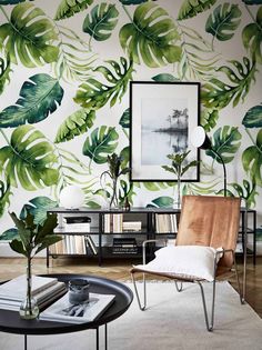 a living room filled with furniture and wallpaper covered in green leaves