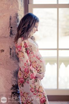 a pregnant woman standing in front of a window