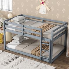 a blue bunk bed sitting on top of a wooden floor next to a white rug