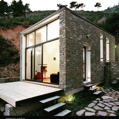 a small house built into the side of a hill with stairs leading up to it