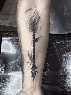 a tattoo on the leg of a man with an arrow