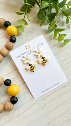 the yellow and black beaded earrings are next to a plant