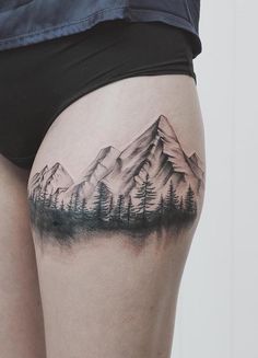 a woman's thigh with mountains and trees tattoo on the side of her thighs