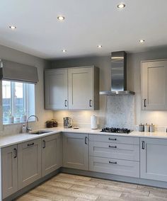 a kitchen with grey cabinets and white counter tops