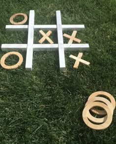 tic - tac - toe game in the grass with wooden pieces and rings