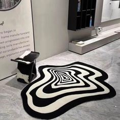 a black and white rug on the floor in front of a wall with an advertisement