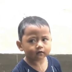 a little boy that is looking at the camera with a surprised look on his face