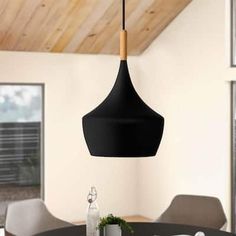 a dining room table with chairs and a black hanging light