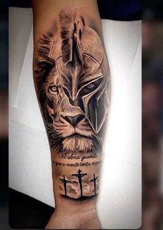 a man's arm with a black and grey tattoo on it, featuring a lion