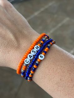 This stack is perfect for all those Soccer Moms, Football moms, baseball moms, etc! Customize them with your team colors, player name, number, school name, mascot, etc!  All bracelets are handmade with stretchy elastic string to allow the bracelet to stretch over your hand and fit snug around your wrist. Excessive stretching or liquids (such as water, perfume, lotions, etc.) may breakdown the elastic and cause the bracelet to break.  Please be sure to provide personalization details and check al Sporty Personalized Stretch Bracelet For Sports Events, Sports Team Beaded Bracelets, Team-colored Sports Event Bracelets, Soccer Bracelets, Sporty Team-colored Beaded Bracelets For Sports Events, Team-colored Bracelets For Sports, Number Bracelets, Soccer Moms, Football Moms