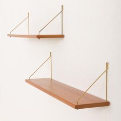 two wooden shelves with metal brackets on them