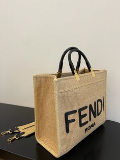 Description FND Sunshine Medium Beige and Black straw shopper Bag For Woman 31cm/12in 8BH386AKRPF1CBX Rep 1:1 Size: 31 x 17 x 35 cm / 12 x 7 x 13.5 inch Medium Sunshine shopper made of natural-coloured woven straw with a moss-stitch effect, with black straw “FND ROMA” embroidery and stiff tortoiseshell-effect plexiglass handles. Features a spacious straw-lined internal compartment, black leather edging and gold-finish metalware. Can be carried by hand or worn on the shoulder thanks to the two ha Fendi Sunshine, Moss Stitch, Beige And Black, Evening Clutch Bag, Shopper Bag, Fendi Bags, Tote Backpack, Cute Bag, Plexus Products