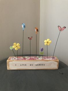 a wooden box with flowers and butterflies in it that says i love my garden on the front