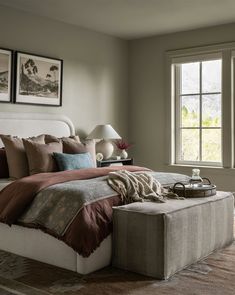 a bedroom with a large bed and two pictures on the wall