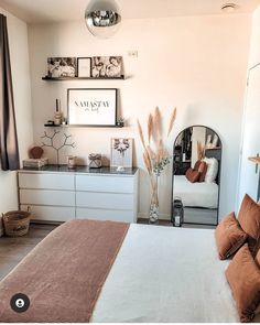 a bed room with a neatly made bed and some pictures on the wall above it