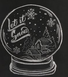 a snow globe with the words let it snow written in white chalk on black paper