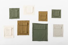 six different colored pieces of cloth on a white surface, each with a small pocket in the middle