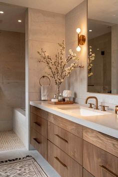 a bathroom with two sinks and a large mirror on the wall above it, along with an area rug