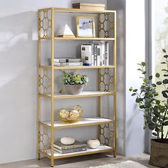 a gold shelf with books and plants on it